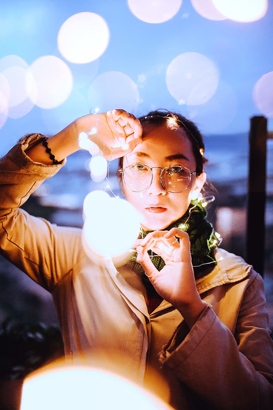 selective focus photography of woman holding string lights, led