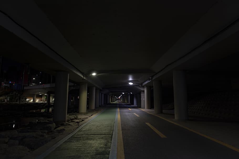 empty gray concrete pathway inside pillared building, corridor
