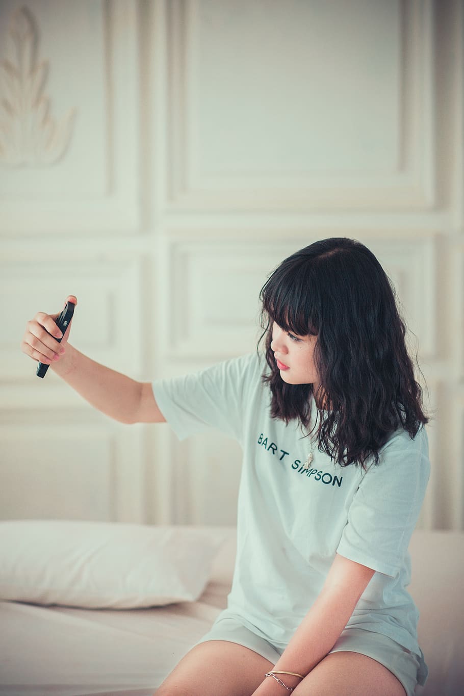 Girl in Blue Crew Neck Shirt Using Her Mobile Phone Indoors, bed HD wallpaper