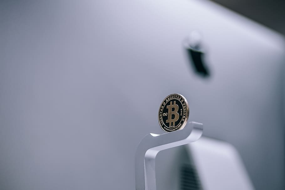 Golden Physical Bitcoin Placed on an iMac. Physical Cryptocurrency Coin.