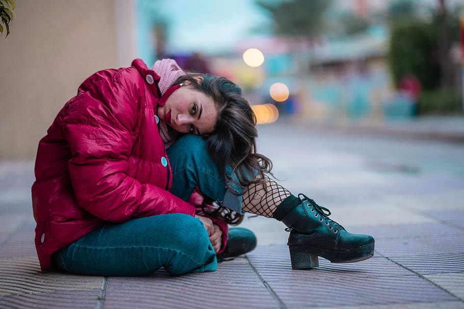 Shallow Focus Photography Of Woman Wearing Red Puffer Jacket Sitting On Sidewalk, HD wallpaper