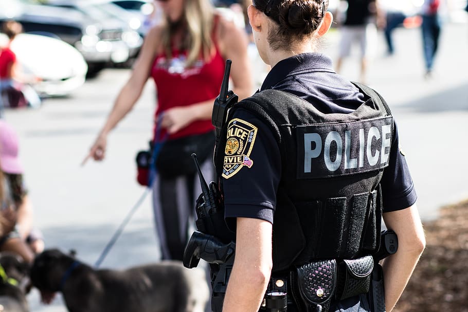 police woman standing near black dog in front of woman wearing red top, HD wallpaper