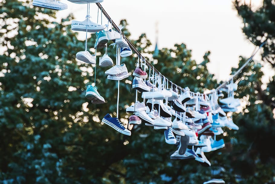 Shoes hanging on a line at city park. Prague, CZE, focus on foreground