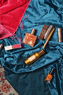 assorted cosmetics on teal textile, bottle, person, human, couch HD wallpaper