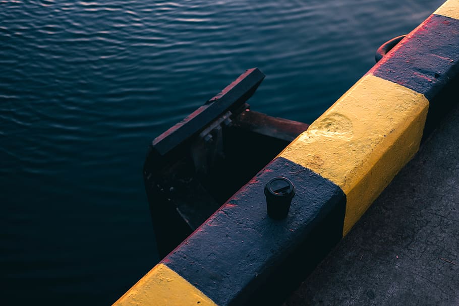 Yellow and Black Painted Bar Near Body of Water, concrete, daytime HD wallpaper