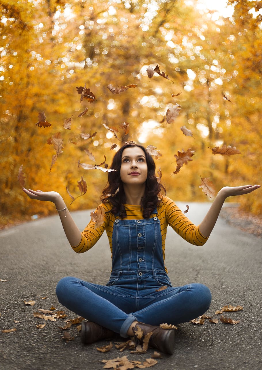 sitting person with crossed legs throwing leaves on air, one person HD wallpaper