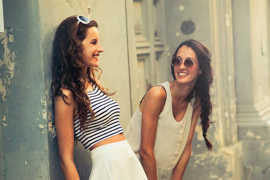Two brunette women with sunglasses standing on the street, 20-25 year old