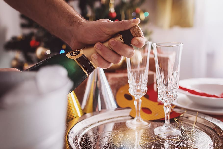 Man Opening Champagne In Room Decorated For Christmas, human hand HD wallpaper