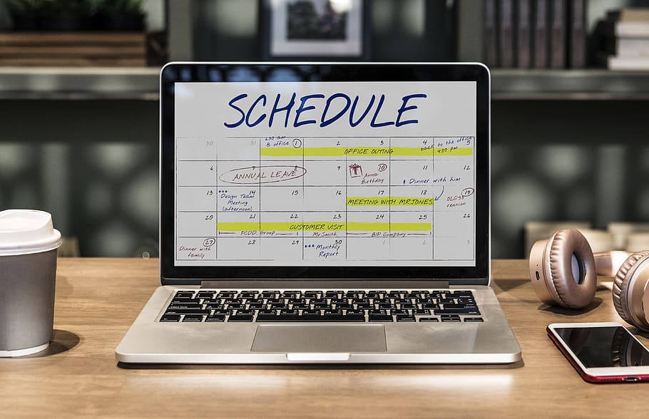 Macbook Pro Turned-on Displaying Schedule on Table, blurred background