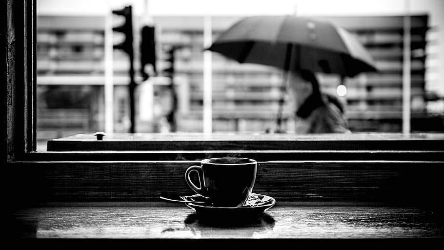 grayscale photo of teacup on tabletop, window, saucer, umbrella