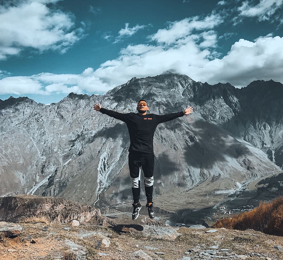 man arms wide open, jump, air, mountain, action, travel, young HD wallpaper