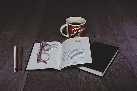 clear eyeglasses on top of white book page near white ceramic mug HD wallpaper