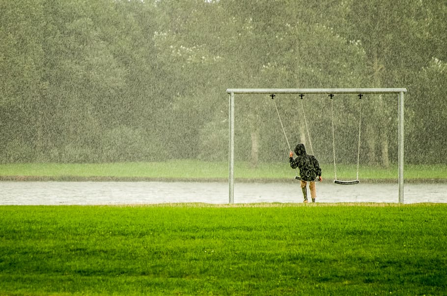Person In Black Hoodie Riding Swing While Raining, daylight, field HD wallpaper