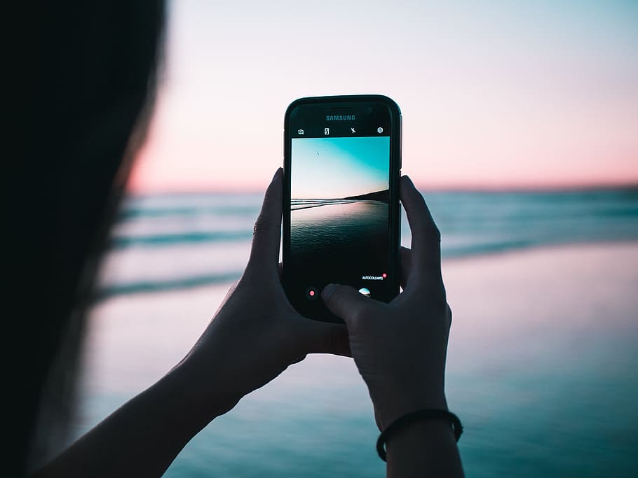 shallow focus photography of person taking photo body of water HD wallpaper