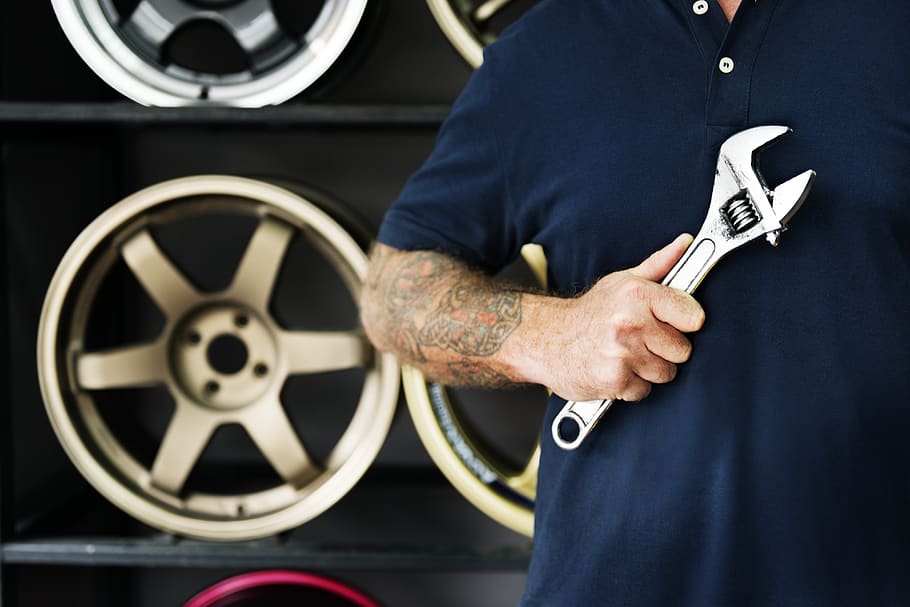 Person Holding Silver Crescent Wrench Behind Vehicle Wheels, blue HD wallpaper