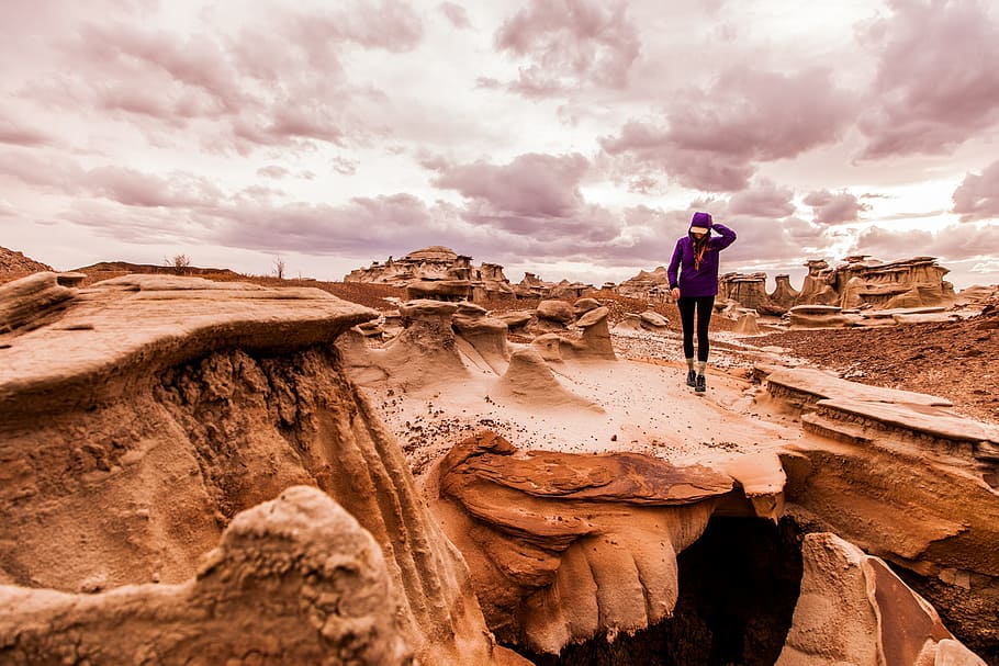 Person Walking on Rock Formation Under Cloudy Sky, arid, barren, HD wallpaper