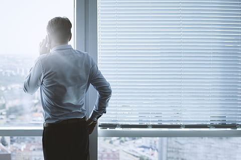 Back view portrait of a businessman talking on the phone at office HD wallpaper