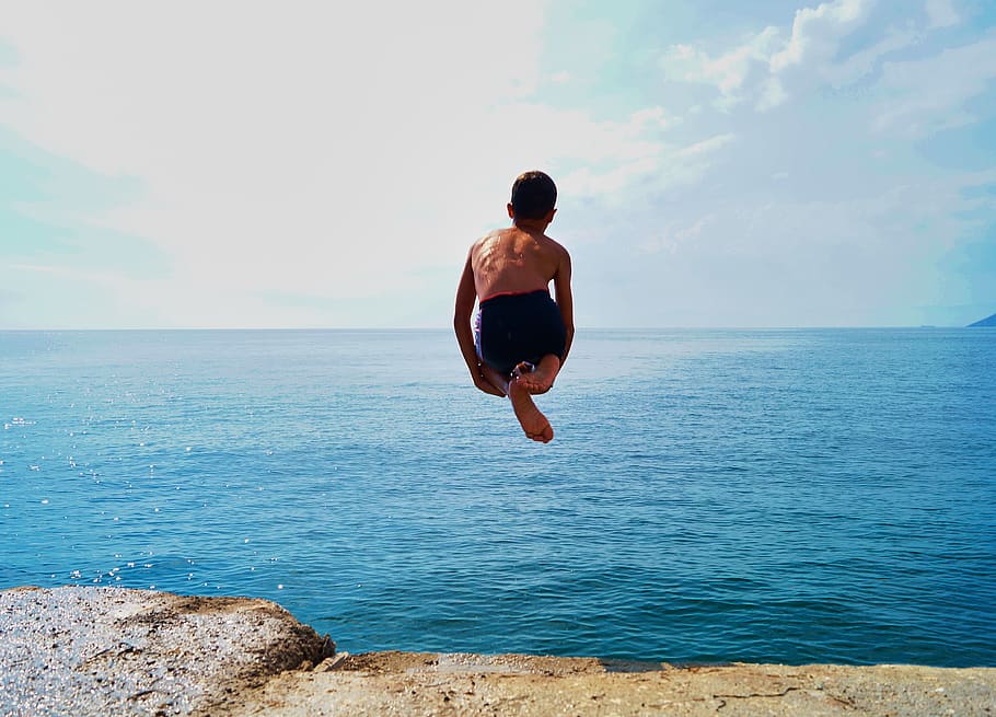 Time Lapse Photography of Boy in Black Shorts Jumping on Body of Water HD wallpaper