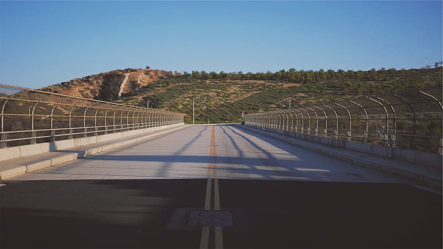 road, pavement, overpass, chainlink, fence, hills, sky, clear sky HD wallpaper