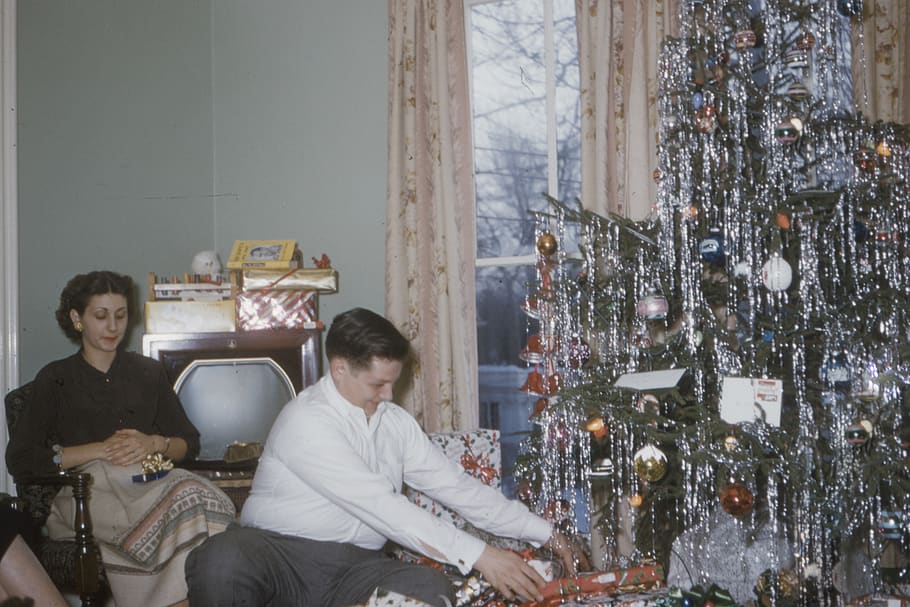 man wearing white shirt sitting near woman and Christmas tree, HD wallpaper