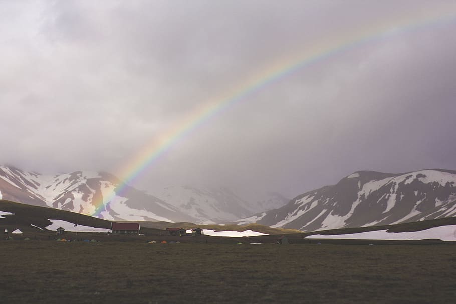 gray mountain near body of water under white rainbow, mountian