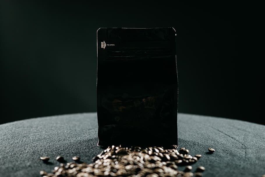 brown coffee beans with pack, black background, indoors, studio shot HD wallpaper