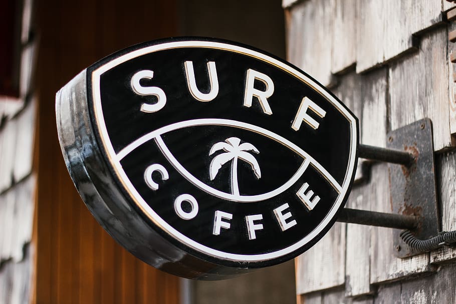 close view of Surf Coffee signage, trademark, logo, symbol, wristwatch
