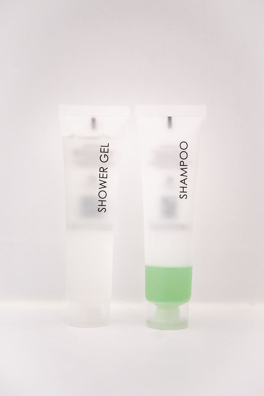 shower gel and shampoo soft-tube bottles on white surface, studio shot