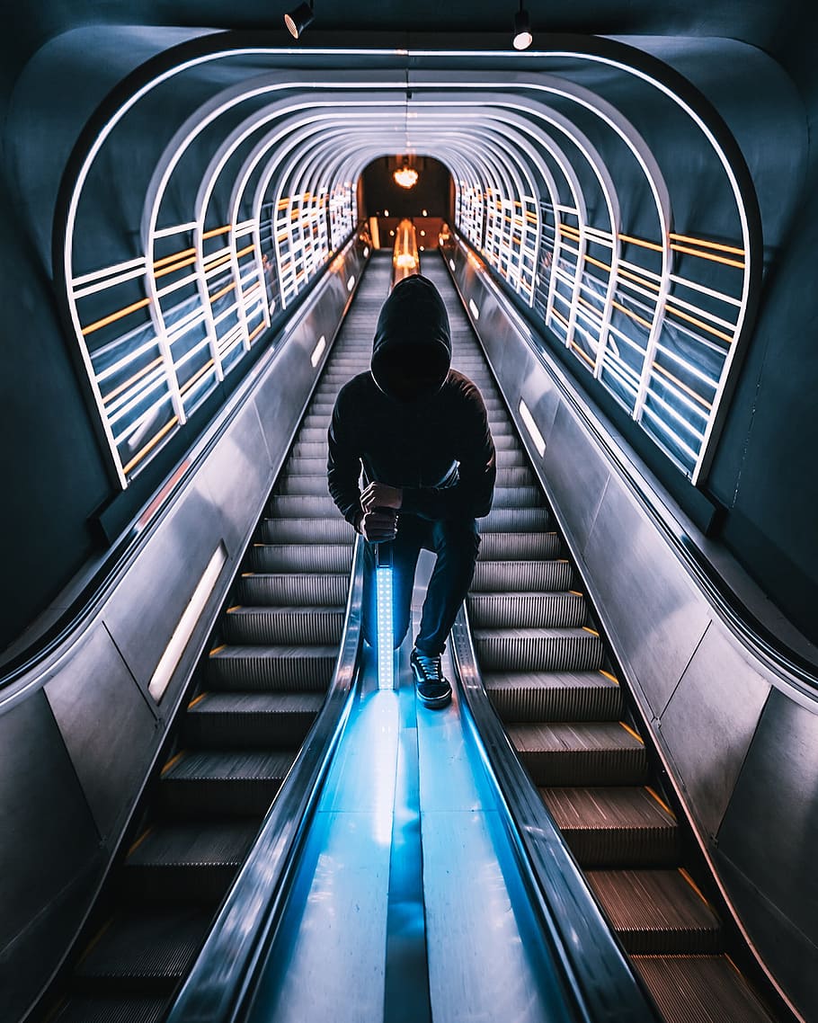 person standing between escalators, urban, lightsaber, tunnel