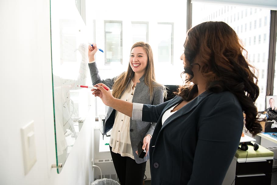 Two Women in Front of Dry-erase Board, discussing, facial expression HD wallpaper