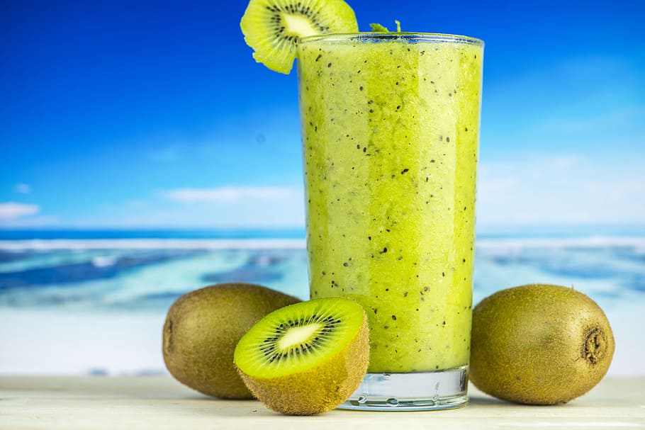 Kiwi Fruit Beside Drinking Glass Filled With Kiwi Shake, beach