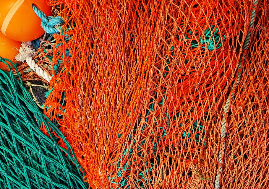 orange and green nets neatly piled, commercial fishing net, fishing industry