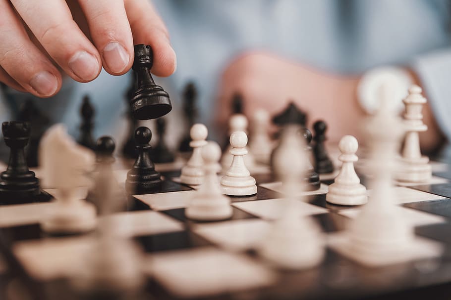 Young businessman playing chess in the office, board game, leisure games