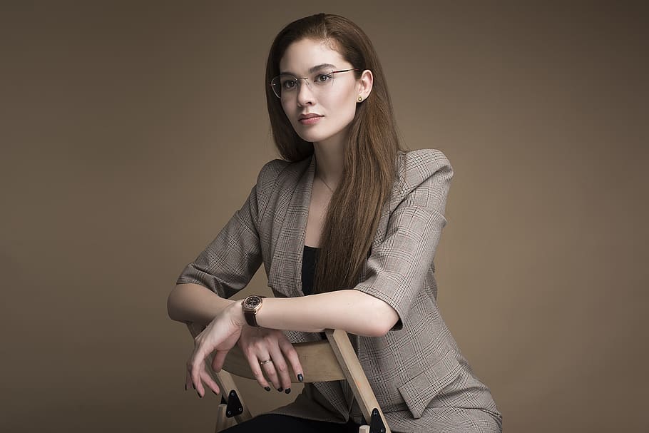 woman in black tube top and brown blazer sitting on chair, apparel