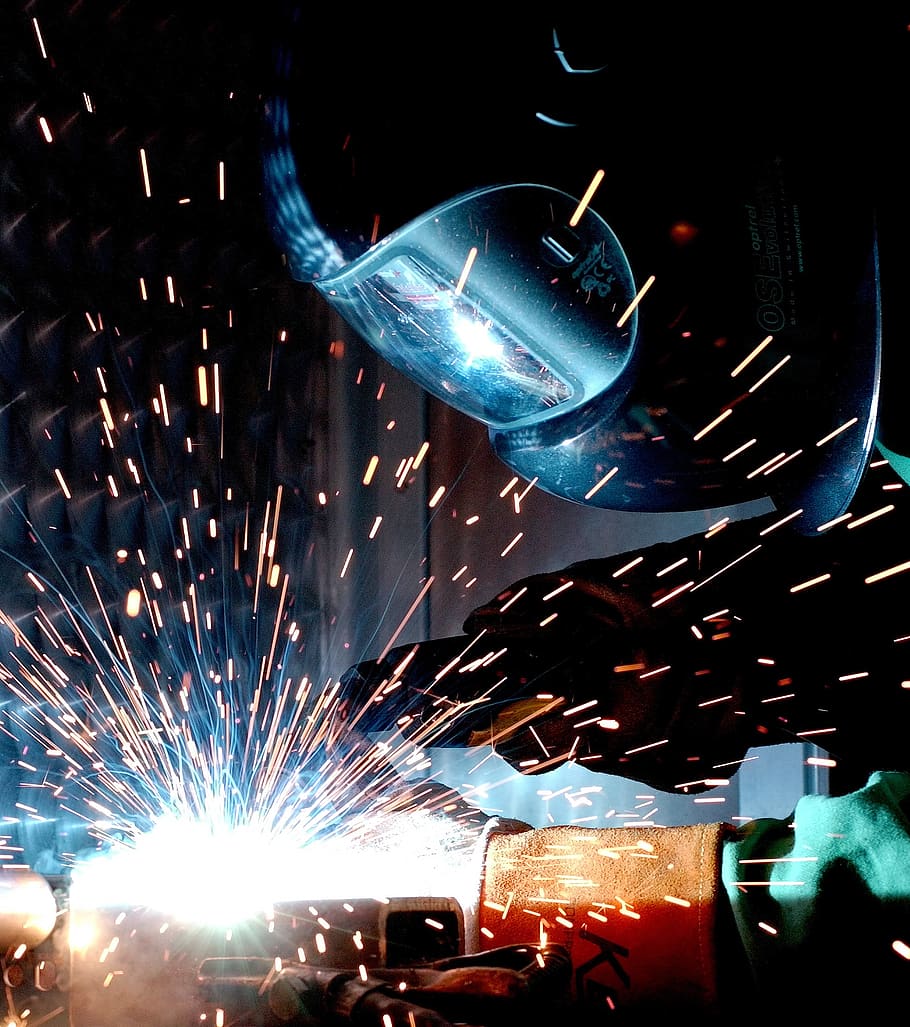 Person in Welding Mask While Welding a Metal Bar, construction