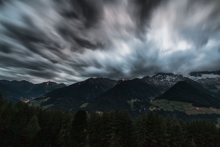 Time Lapse Photography of Pine Trees Near Mountains Under Grey Clouds HD wallpaper