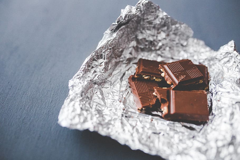 Chocolate pieces on aluminum foil, candy, still life, indoors HD wallpaper