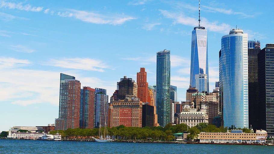 Battery Park with Lower Manhattan skyline looming behind on a sunny summer day., HD wallpaper