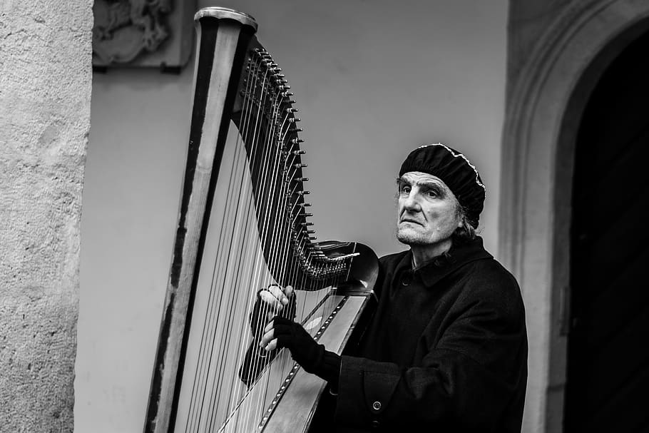grayscale photo of man, person, human, musical instrument, harp