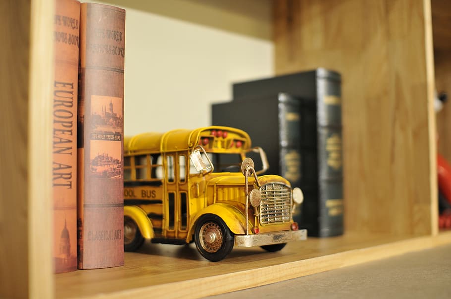 Yellow Bus Die-cast Model on Shelf Between Books, action, blur HD wallpaper