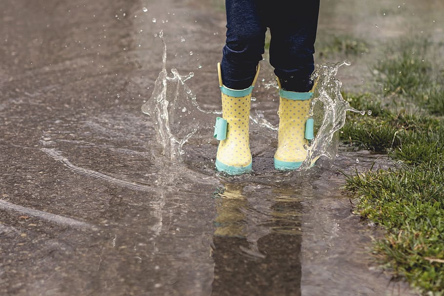 person wearing yellow rain boots, puddle, human, apparel, clothing
