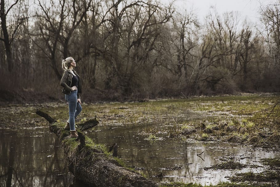 Woman Standing on Driftwood Above Body of Water, daylight, environment HD wallpaper