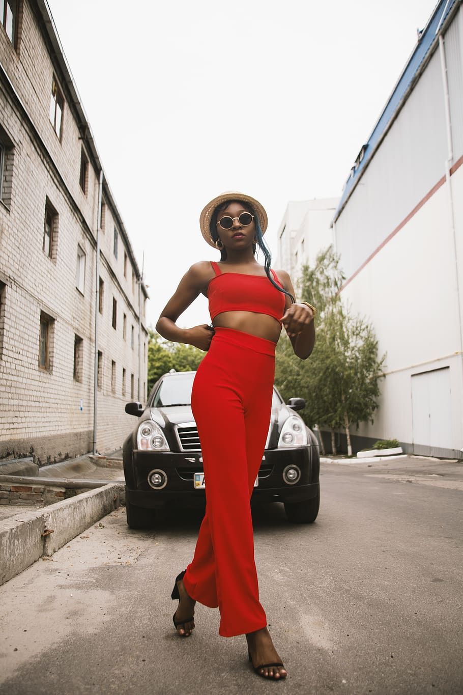 Women's Black Tank Top and Red Track Pants Walking on Street