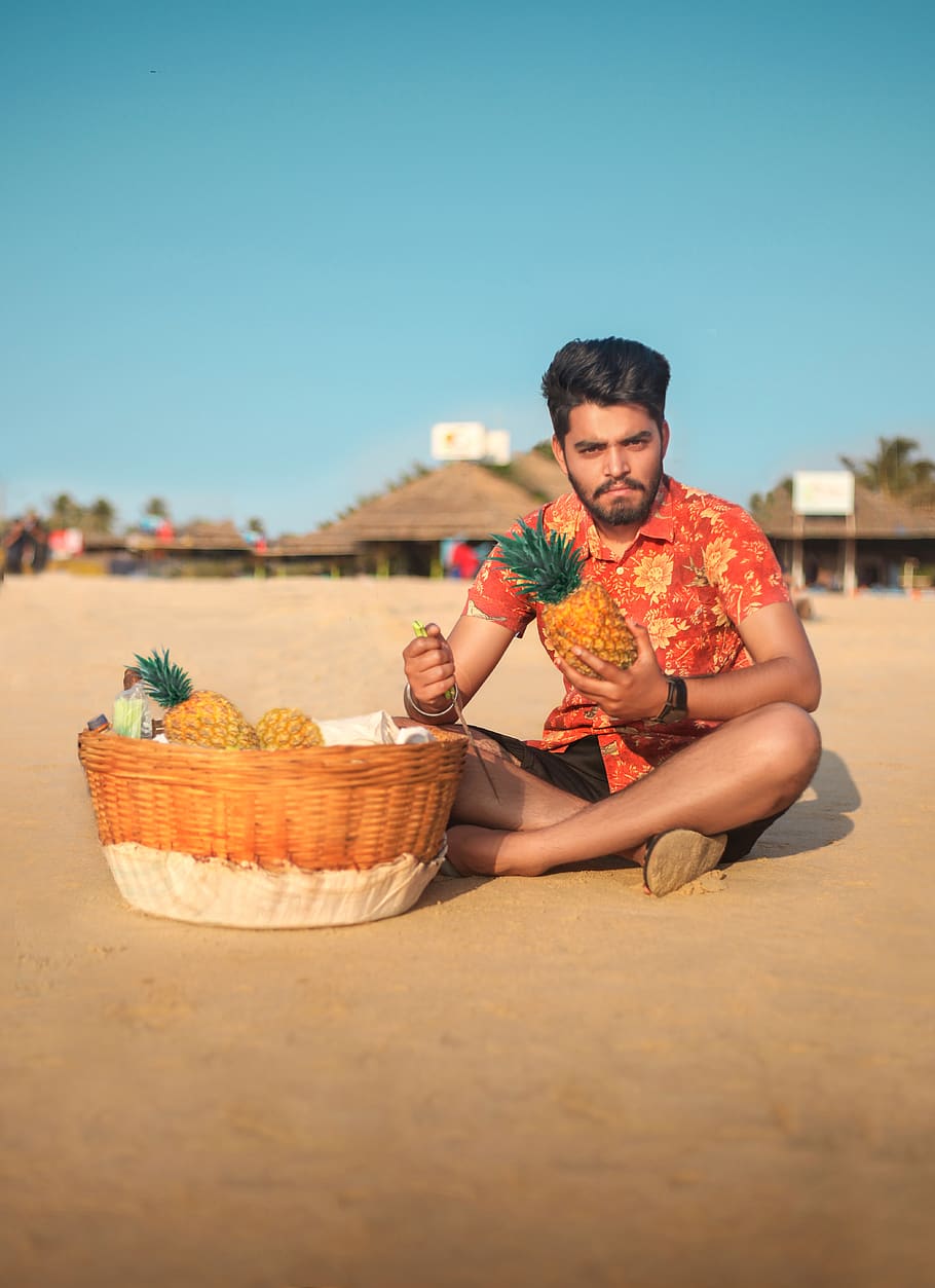 Photo of Man Sitting on Sand with Fruit Basket in front of Him Holding a Pineapple, HD wallpaper