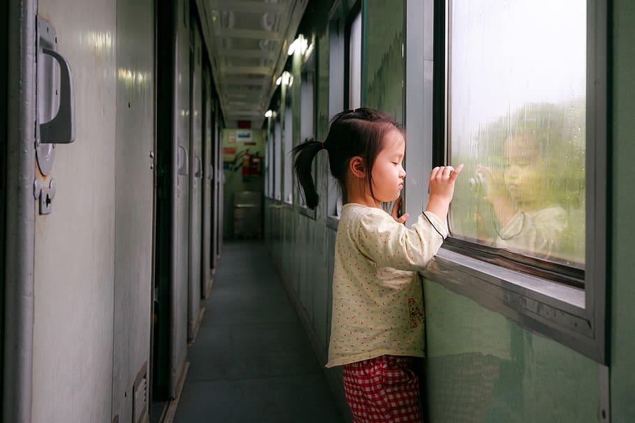 Photo of Girl Standing by Window in Train Hallway Looking Outside While Taking a Photo HD wallpaper