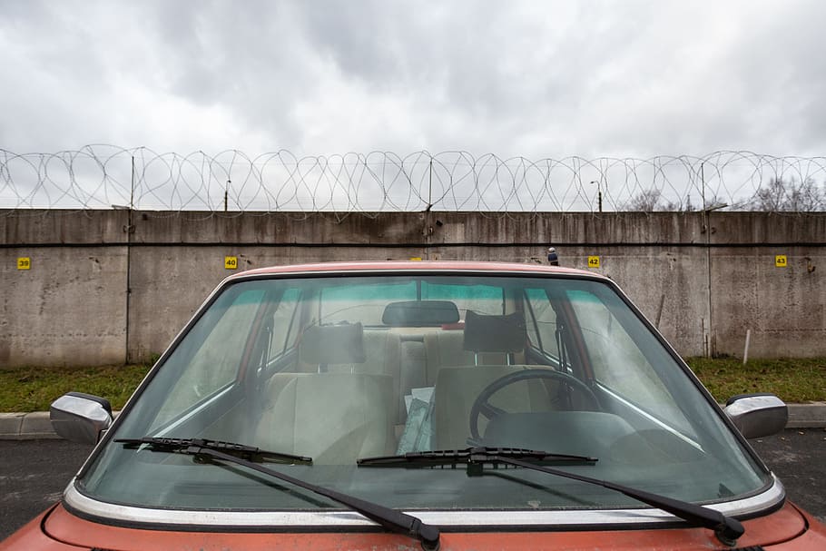 Closeup Photo of Red Car Near Concrete Wall, asphalt, auto, barbed wire HD wallpaper