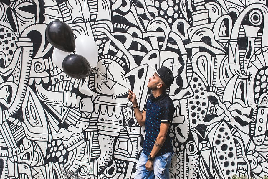 man holding two black balloons, one person, standing, casual clothing HD wallpaper