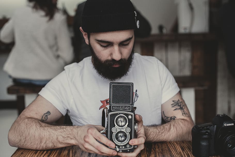 man holding vintage black and gray camera, skin, human, person