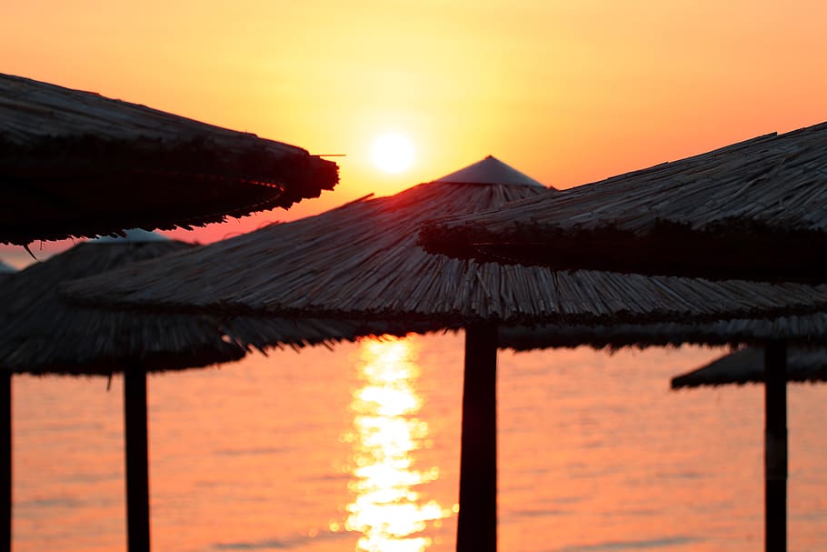 sunset, beach, parasol, water, sea, ocean, sky, summer, vacations HD wallpaper