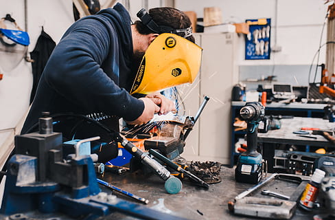 man wearing black hoodie using welding tool, work, spark, mask HD wallpaper